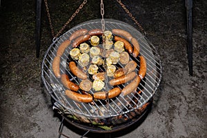 Baking sausages, sheeps cheese and corn on a metal grate fired with birch wood.