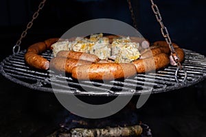 Baking sausages, sheeps cheese and corn on a metal grate fired with birch wood.