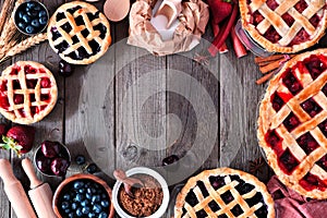 Baking scene frame with an assortment of homemade fruit pies over a wood