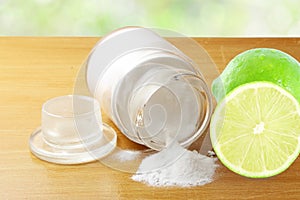 Baking soda or baking powder in glass bottle with lemon fruit photo