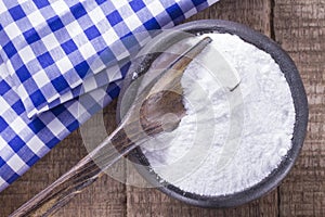 Baking soda in bowl on wooden table