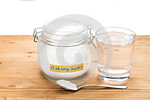 Baking soda in jar, spoonful and glass of water for multiple hol