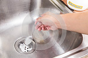 Baking soda poured to unclog drainage system at home.