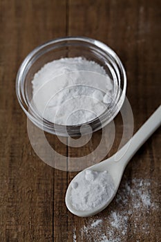 Baking soda, Sodium bicarbonate in glass bowl and spoon on table