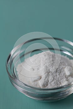 Baking soda, Sodium bicarbonate in glass bowl and spoon on table