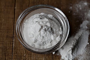 Baking soda, Sodium bicarbonate in glass bowl and spoon on table