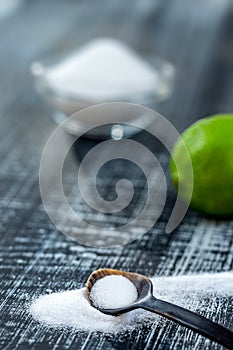 Baking soda - sodium bicarbonate and lemon. Natural, powder on a grey wooden background