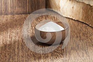 Baking soda sodium bicarbonate in a wooden bowl; Photo on wooden background