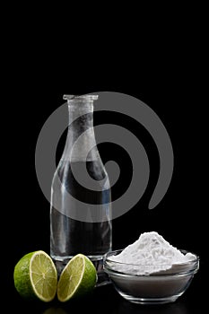 Baking soda, vinegar and cut lemons on blacwooden table, flat lay.