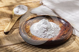 Baking soda in wooden bowl on the table