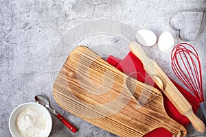 Baking theme for Valentine`s Day. Kitchen utensils, a cutting board and baked goods are on a gray background.