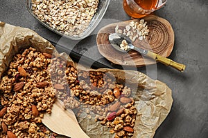 Baking tray with tasty granola and oatmeal on grey table