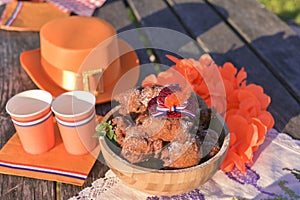 Baking and various foods and drinks for lunch on the nature. Oranjevaya hat and accessories. Traditional donuts for King`s Day
