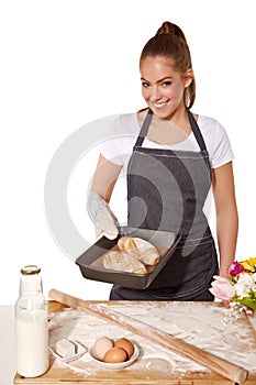 Baking woman showing a tray of fresh bread roll (made of rye flour)