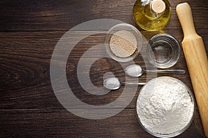 Baking wooden background with ingredients for pizza dough.