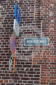 Bakkersstraat Sign on Brick Wall with Traffic Signs in Belgium