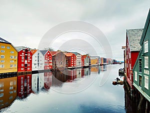 Bakklandet with colorful riverfront houses reflecting on the water in Trondheim, Norway