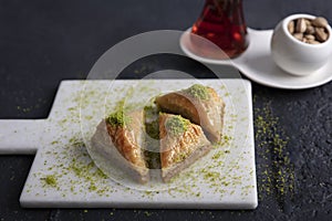 Baklava shop. Turkish pistachio and yufka dessert, a plate of pistachio baklava on a marble tray