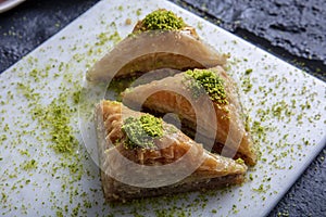 Baklava shop. Turkish pistachio and yufka dessert, a plate of pistachio baklava on a marble tray