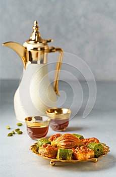 Baklava sweets with Arabic Coffee pot Dallah and cup of traditional  cardamon coffee  Qahwa