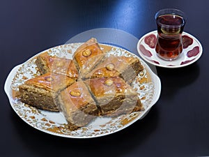 Baku pakhlava on a platter with tea poured into a glass of Armud