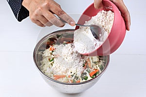 Bala-bala or Bakwan Ingredients, Pour Flour to Mixed  Vegetables on the Bowl.