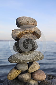 Balance pebble stone in the stoned beach at sunset. Stack of zen stones in harmony and balance with sea view. minimalist view of a