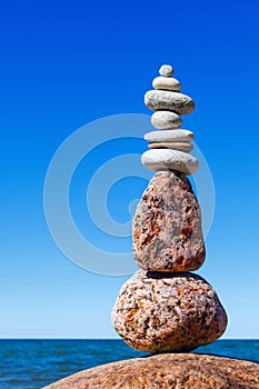 Balance and poise stones against the sea. Rock zen on the background of blue sky