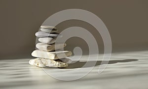 Balance pyramid stones on grey background, sunlight and shadows. Copy space