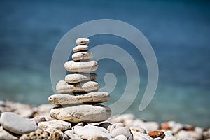 Balance pyramid of stones on the sea. Small pebble pillar. A symbol of calmness and tranquility.