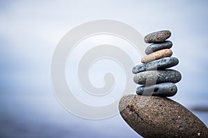 Balance, relaxation and wellness: Stone cairn outside, ocean in the blurry background