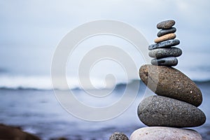 Balance, relaxation and wellness: Stone cairn outside, ocean in the blurry background