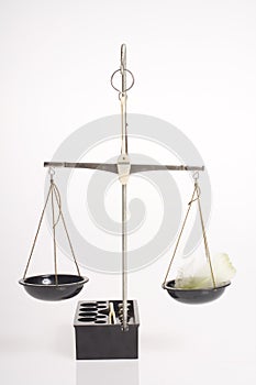 Balance scale with feather on white background