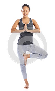 Balance and serenity. A beautiful young woman doing a yoga pose against a white background.