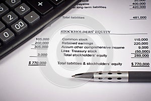 Balance sheet, calculator and pen