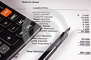 Balance sheet, calculator and pen