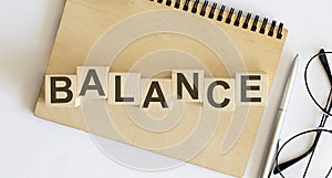 Balance . Solution word written on the wood block on the wooden notebook