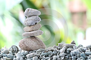 Balance stone on pile rock with garden background.