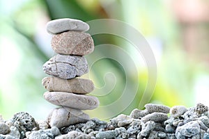 Balance stone on pile rock with garden background.