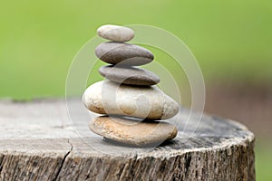 Balance Stones stacked to pyramid in the soft green background.