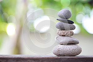 Balance Stones stacked to pyramid in the soft nature green background.