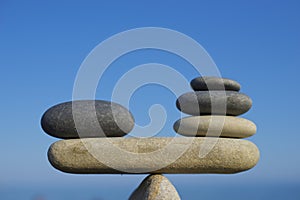 Balance of stones. To weight pros and cons. Balancing stones on the top of boulder. Close up.