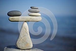 Balance of stones. To weight pros and cons. Balancing stones on the top of boulder. Close up.