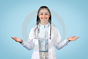 Balanced female doctor with open palms, blue backdrop