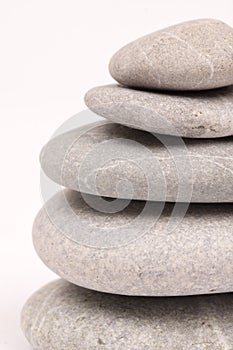 Balanced grey stones over white background