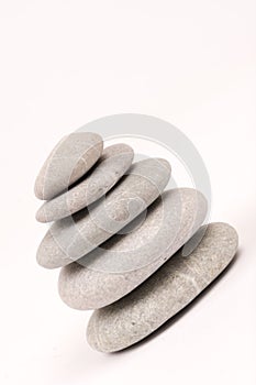 Balanced grey stones over white background