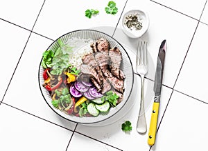 Balanced lunch - grilled beef steak, vegetables and rice on a light background, top view