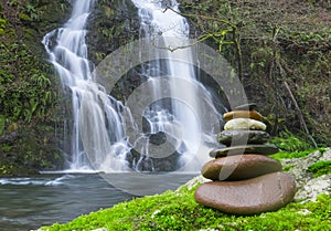 Balanced Rock Zen Stack in front of waterfall.