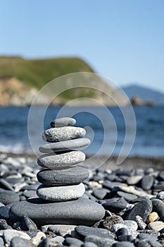 Balanced stone pyramide on the beach with black and grey stones