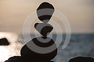 Balanced stones on the beach at sunset